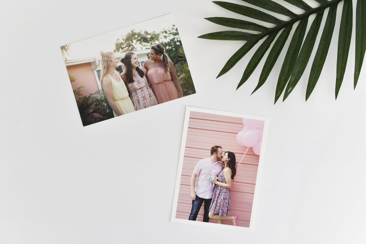 Two photo prints resting on a white table.