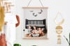 A Fine Art Print of a family portrait hangs from Oak Poster Rails in a child's bedroom.