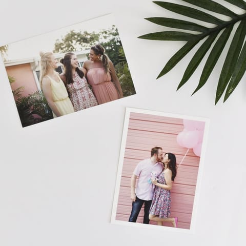Two photo prints resting on a white table.