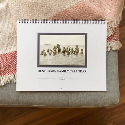 The cover of a Family History Wall Calendar shows a large family swimming and the title, Henderson Family Calendar 2022. The cover of a Family History Wall Calendar shows a large family swimming and the title, Henderson Family Calendar 2022.