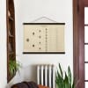 A Family Tree Poster with a vintage inspired design, showing the Henderson family, hangs from poster rails next to a bookshelf.