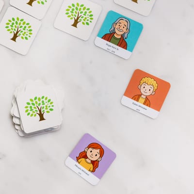 MyCanvas Family Flip memory game cards on a marble surface, with illustrated family-member portraits of Roger Kent Sr., Dylan, and Mikayla Whitaker.