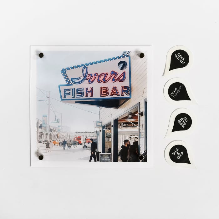 A Square Print is held in place by a magnet in each corner. Next to the print are four magnetic stickers.