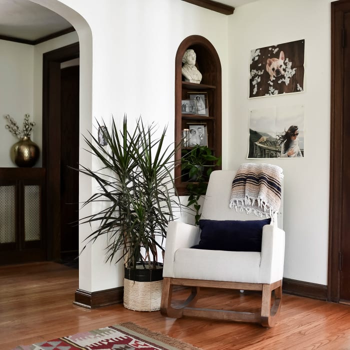 Two Newsprints hang from restickable Good Hangup magnets above a beige rocking chair in a sitting room.