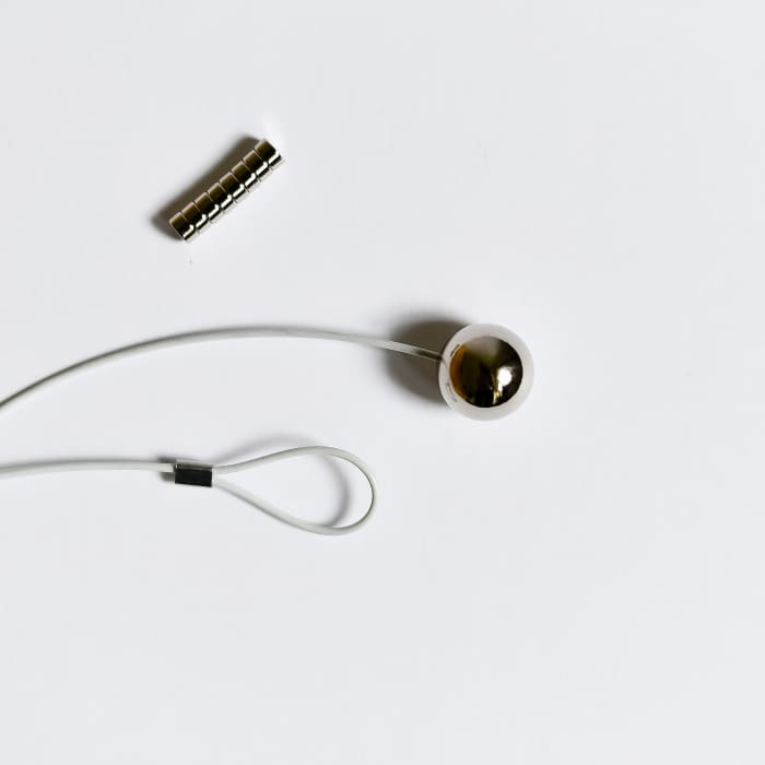 A closeup of the included magnets, end loop, and magntic ball of a Photo Rope.