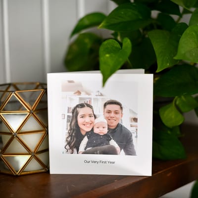 A 6x6 Softcover Photo Book titled Our Very First Year with a family photo on the cover A 6x6 Softcover Photo Book titled Our Very First Year with a family photo on the cover