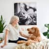 A Square Engineer Print hangs from Maple Poster Rails above a bed. A dog and its owner sit on the bed.