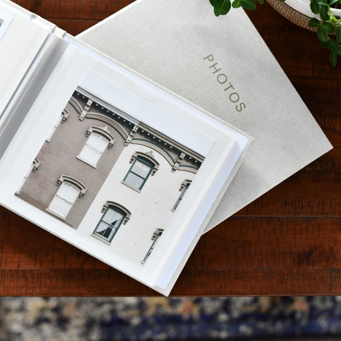 Two Square Print Photo Album lay on a coffee table displaying a large 5.5 inch square print of a vacation photo.