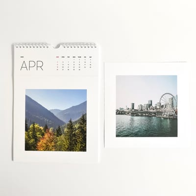 A Keepsake Wall Calendar and the square photo portion of another calendar page are placed side by side. A Keepsake Wall Calendar and the square photo portion of another calendar page are placed side by side.