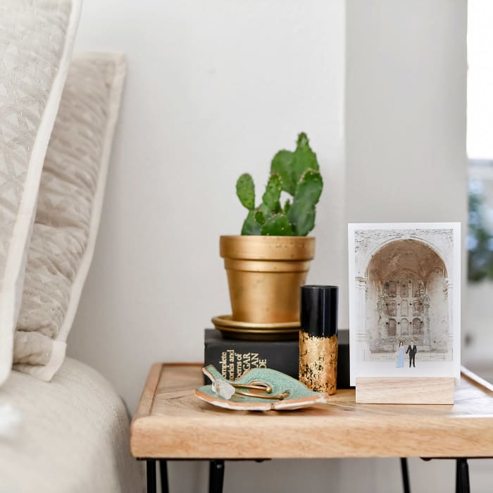 A wedding photo printed as a 5x7 Classic Print is held by an oak Wood Block sits on a nightstand.
