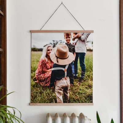 A Fine Art Print showing a sweet family photo hangs from Parabo Press 24 inch Oak Poster Rails.