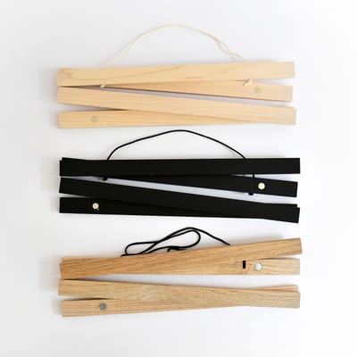 Light wood Maple, painted Black, and darker wood Oak Poster Rails show the magnets inside that help them hang prints damage-free. Light wood Maple, painted Black, and darker wood Oak Poster Rails show the magnets inside that help them hang prints damage-free.