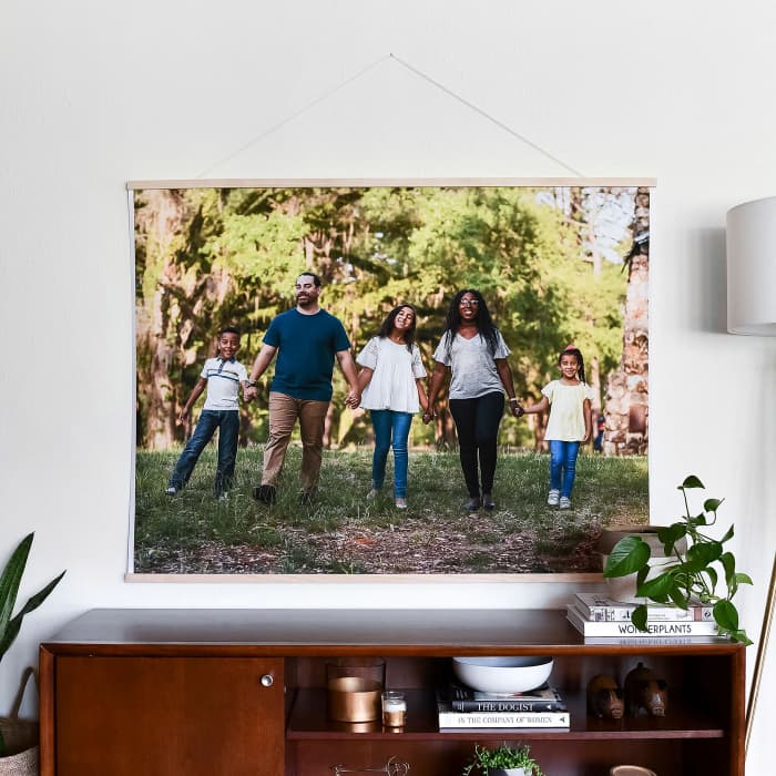 An Engineer Print featuring a family portrait hangs above a credenza from 48 inch Maple Poster Rails.
