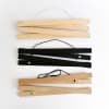 Light wood Maple, painted Black, and darker wood Oak Poster Rails show the magnets inside that help them hang prints damage-free.